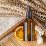 Bottle of Serum on Wooden Tray with Dried Orange Slice