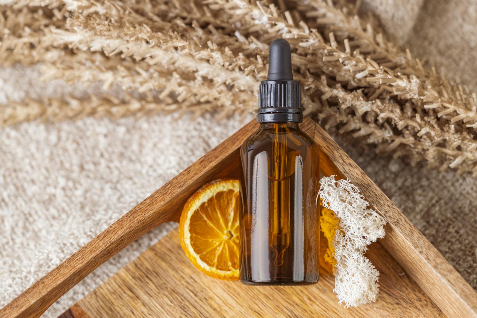 Bottle of Serum on Wooden Tray with Dried Orange Slice